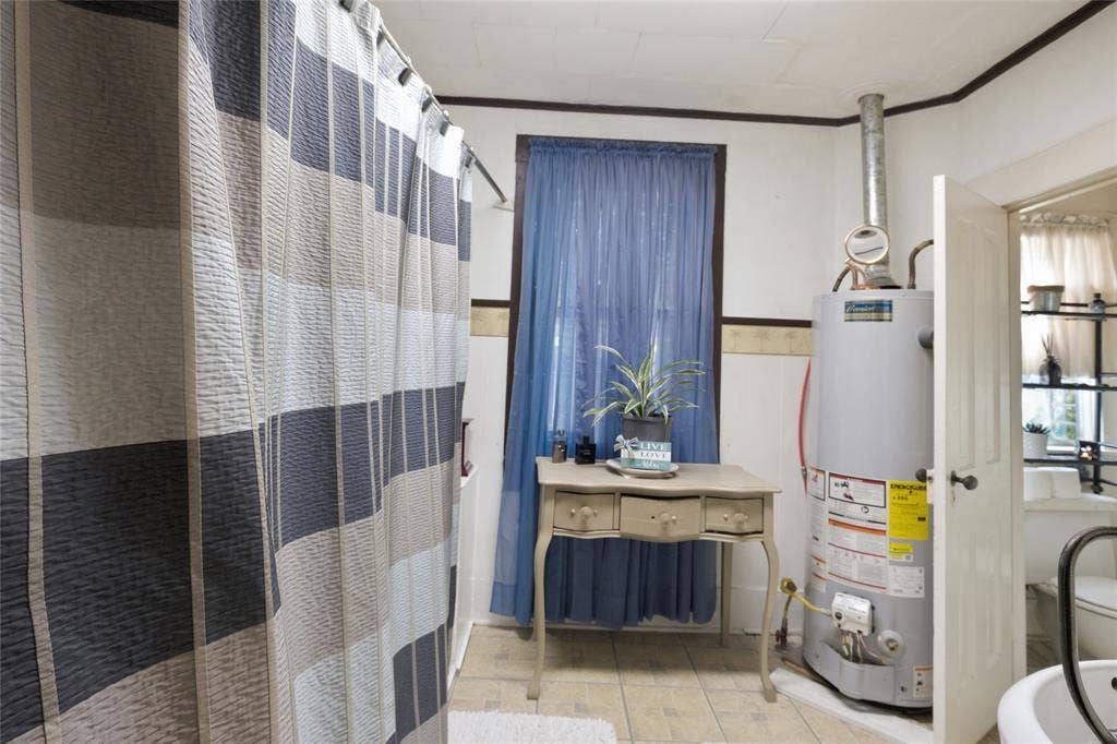 2309 Jones Street, Greenville, TX 75401 Bathroom featuring tile flooring and a vertical water heater