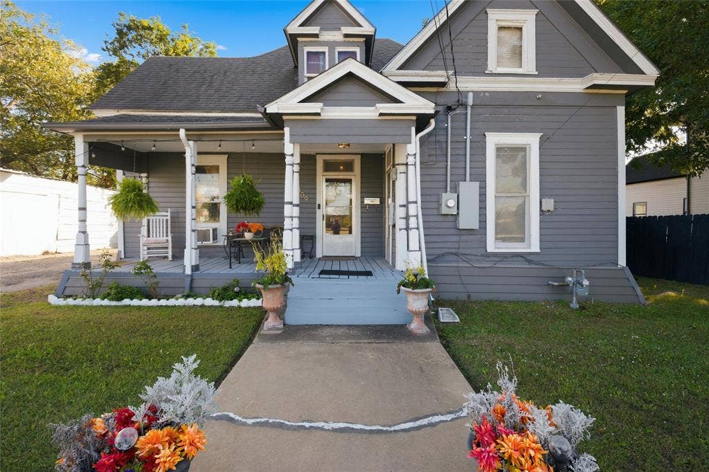2309 Jones Street, Greenville, TX 75401 Craftsman-style exterior featuring horizontal siding, a covered front porch with decorative columns, a gabled roofline, and a central entryway with a glass-paneled door