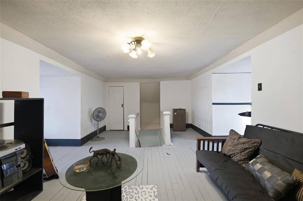 2309 Jones Street, Greenville, TX 75401 Painted wood-finish flooring, multi-bulb flush-mount ceiling light fixture, and white interior door