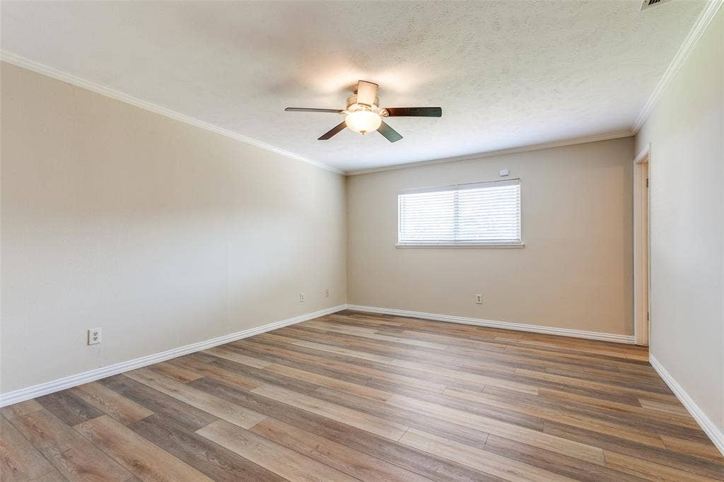 929 Arbor Downs Drive, Plano, TX 75023 Neutral-toned interior space featuring wood-finish flooring, a ceiling-mounted light fixture with fan, and a window with horizontal blinds