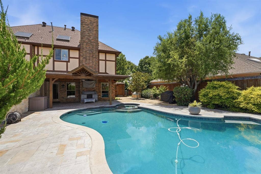 1509 Aylesbury Lane, Plano, TX 75075 View from back of pool to the home. Take a look at that oversized covered patio, great for gathering outside in the Fall.