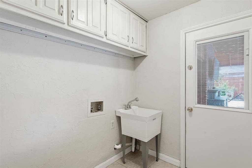 1509 Aylesbury Lane, Plano, TX 75075 Laundry room offers a wash standalone sink and overhead cabinets.