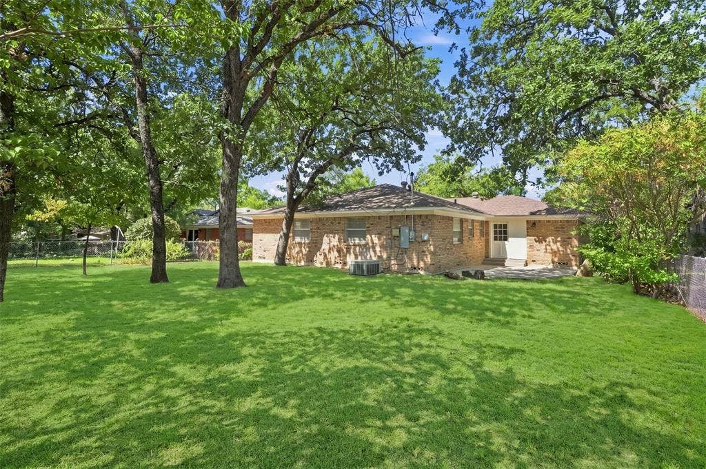 Expansive green lawn framed by mature trees