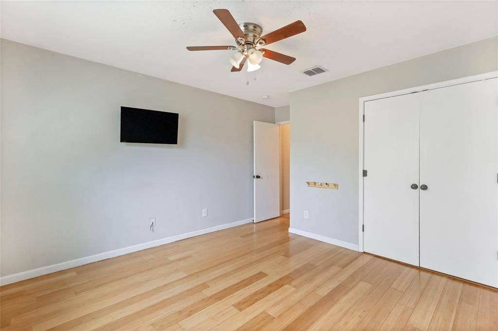 Unfurnished bedroom featuring light wood-style flooring, a ceiling fan, and a closet