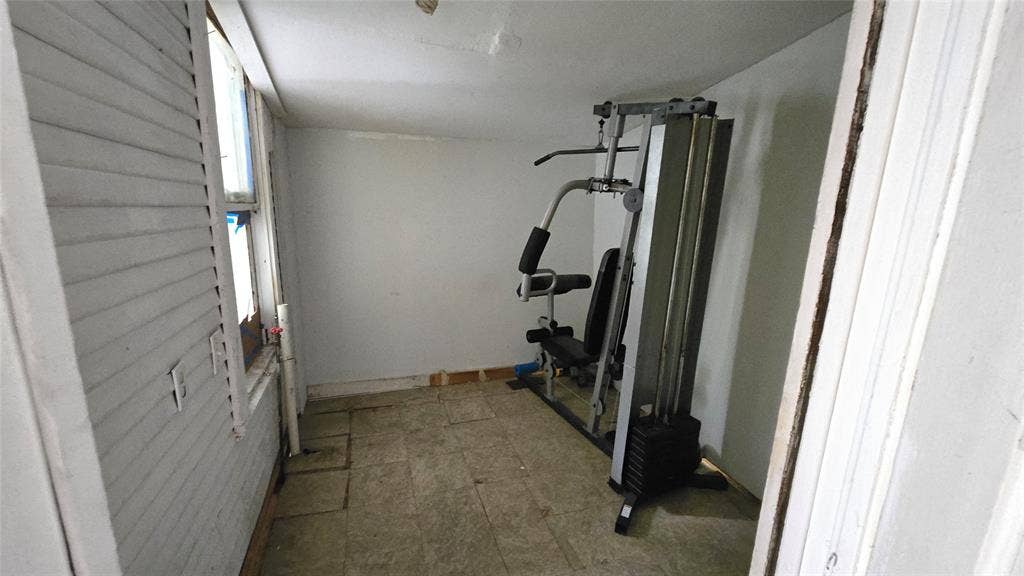 922 Hollywood Avenue, Dallas, TX 75208 Enclosed space featuring tile flooring, painted wall surfaces, and a multi-pane window with louvered shutter covering