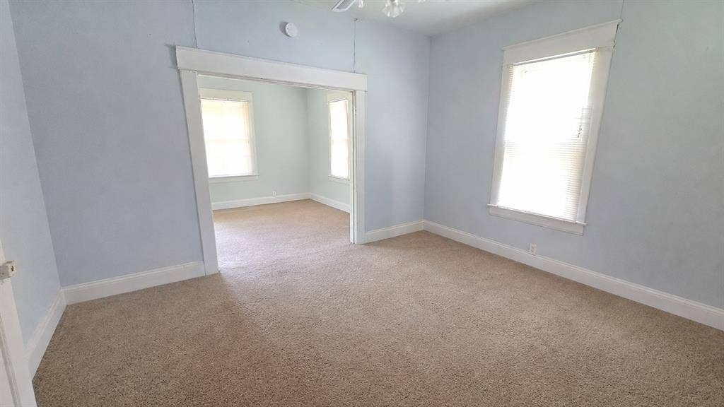 922 Hollywood Avenue, Dallas, TX 75208 Interior space featuring neutral carpeting, wide window casing, and thick door trim