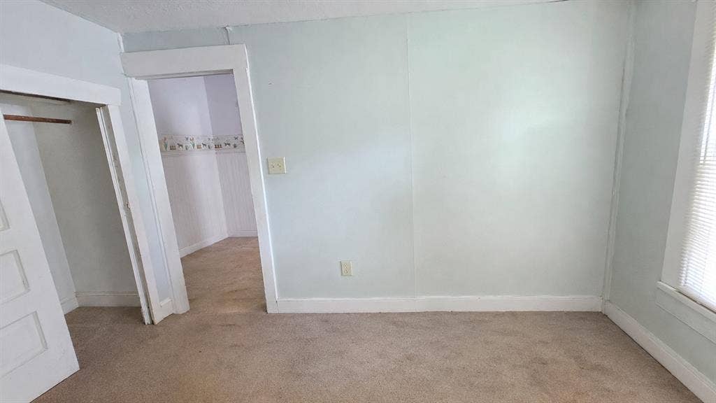 922 Hollywood Avenue, Dallas, TX 75208 Neutral wall paint, carpeting, built-in closet, and interior doorway featuring white trim