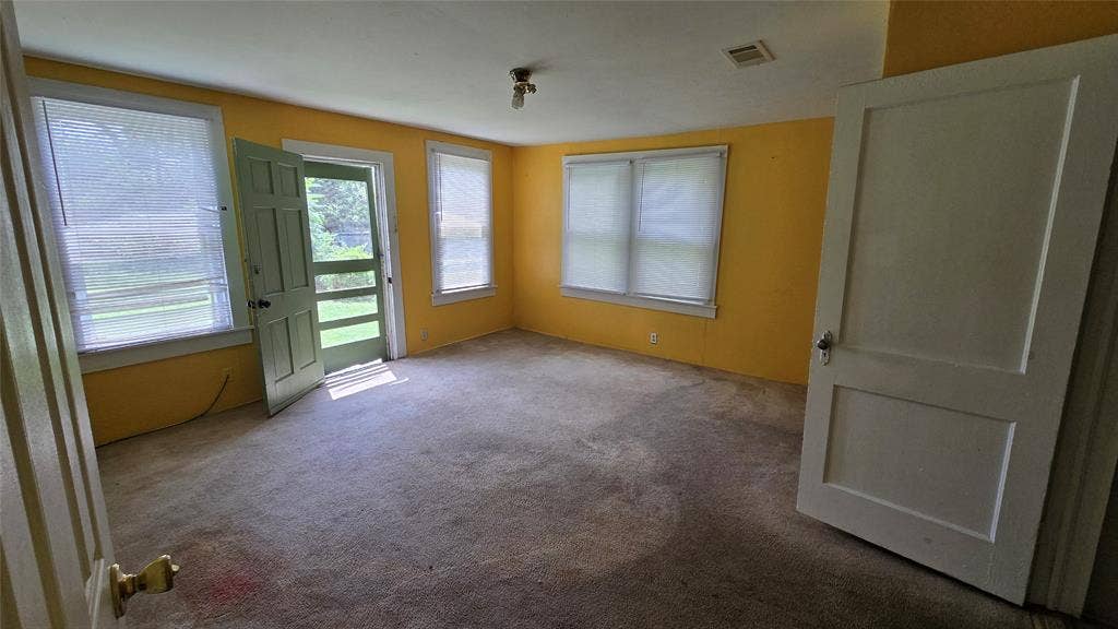 922 Hollywood Avenue, Dallas, TX 75208 Interior room featuring three double-hung windows, wall-to-wall carpeting, and a multi-pane glass exterior door