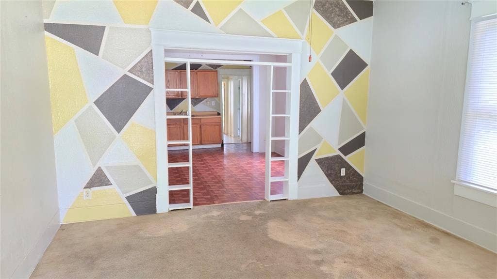 922 Hollywood Avenue, Dallas, TX 75208 Interior room featuring geometric wall detailing and built-in side shelving surrounding a wide doorway