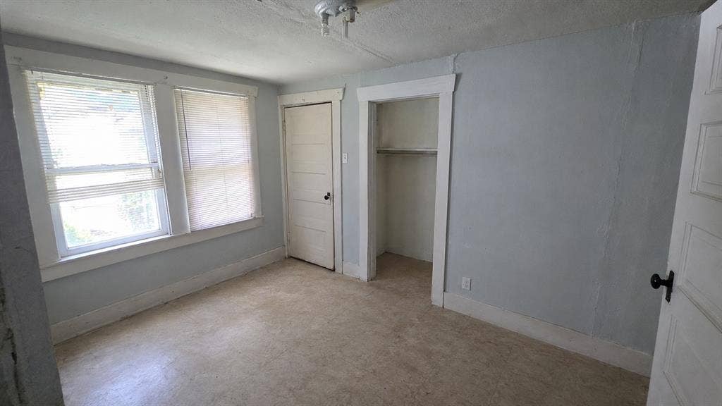 922 Hollywood Avenue, Dallas, TX 75208 Interior room featuring dual windows with integrated blinds, a closet with shelving, a four-panel door, and a ceiling-mounted light fixture