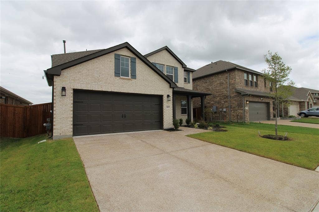 2603 Swallowtail Street, Melissa, TX 75454 Two-story residence featuring a light-toned brick facade, dark-finish shutters, a concrete driveway, a multi-car garage, and a covered entry