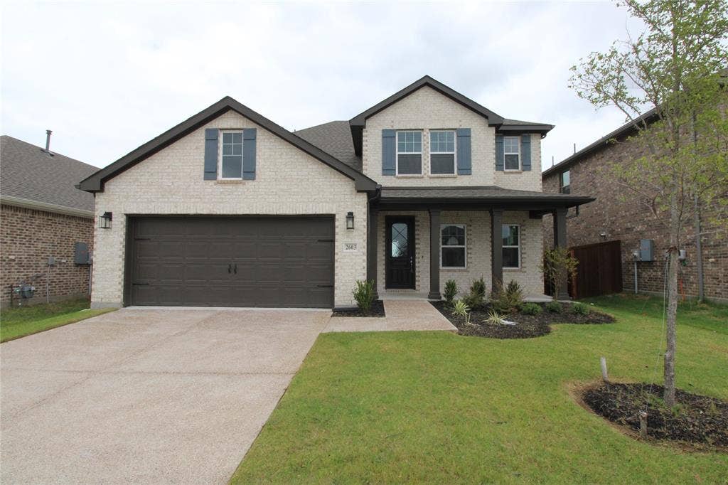 2603 Swallowtail Street, Melissa, TX 75454 Two-story brick exterior featuring a multi-gabled roofline, front-facing two-car garage, covered entry porch, and decorative shutters