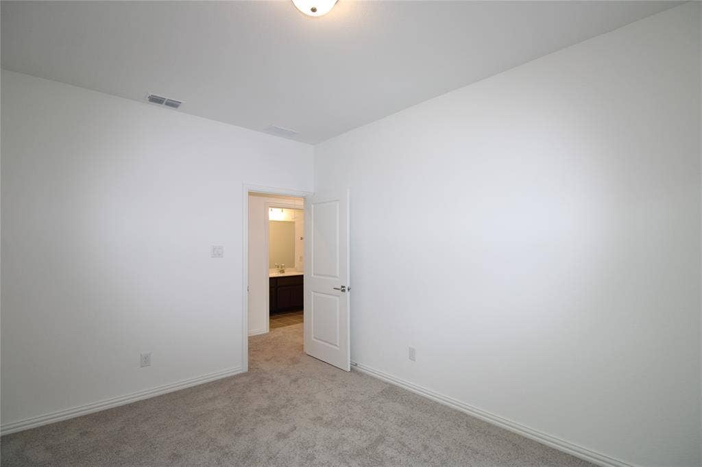 2603 Swallowtail Street, Melissa, TX 75454 Neutral-toned carpeting, smooth-finish walls, ceiling-mounted lighting, and a solid-core two-panel interior door