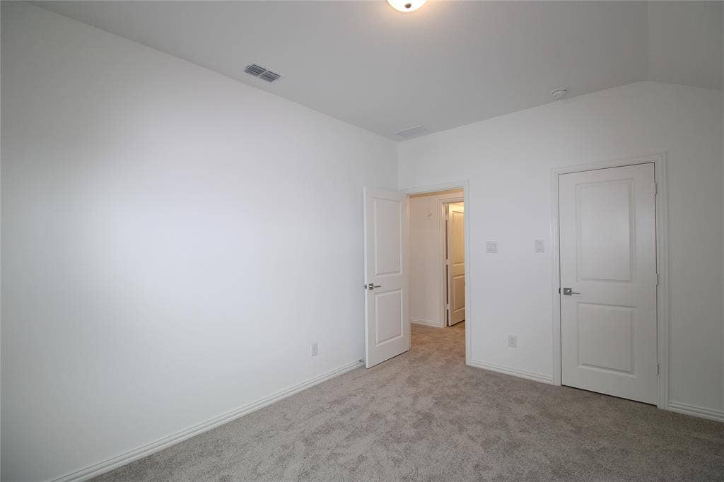 2603 Swallowtail Street, Melissa, TX 75454 Neutral-toned carpeting, vaulted ceiling, and two-panel interior doors