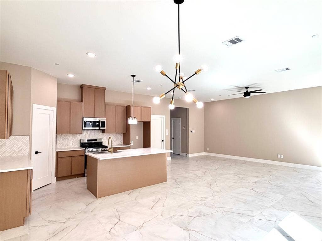 2390 Usman Drive, Irving, TX 75062 Kitchen featuring flat-panel wood cabinetry, quartz countertops, herringbone pattern tile backsplash, stone-finish tile flooring, and a multi-arm geometric chandelier