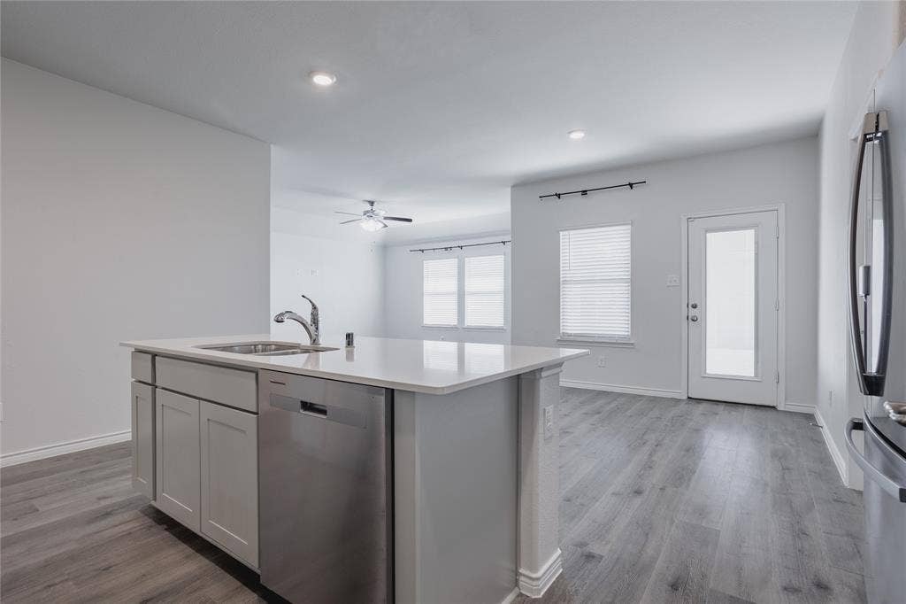610 Overlook Point, Lavon, TX 75166 Kitchen island with solid-surface countertop and stainless steel dishwasher, light-toned cabinetry, wood-finish flooring, and recessed lighting