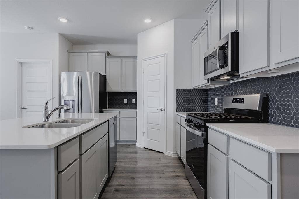 610 Overlook Point, Lavon, TX 75166 Kitchen featuring light gray shaker-style cabinetry, quartz countertops, a dark hexagonal tile backsplash, stainless steel appliances, and wood-finish flooring