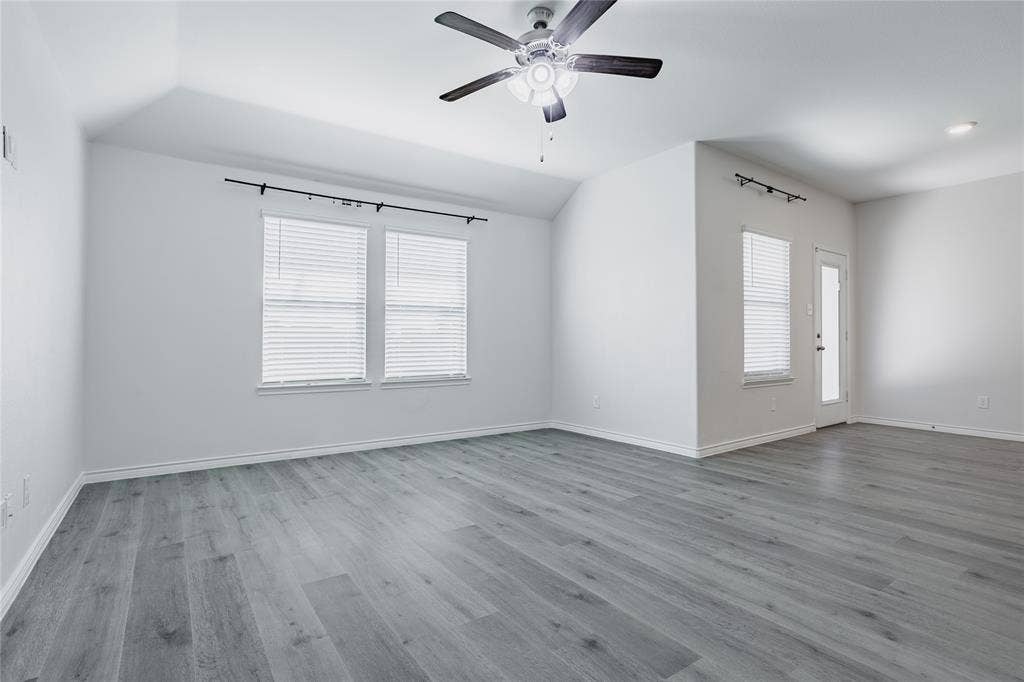 610 Overlook Point, Lavon, TX 75166 Vaulted ceilings, wood-finish flooring, multi-pane windows with horizontal blinds, and a central ceiling fan with integrated lighting