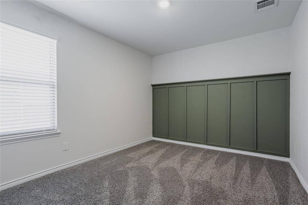 610 Overlook Point, Lavon, TX 75166 Room featuring wall-to-wall carpeting, window blinds, and an olive-toned paneled accent wall