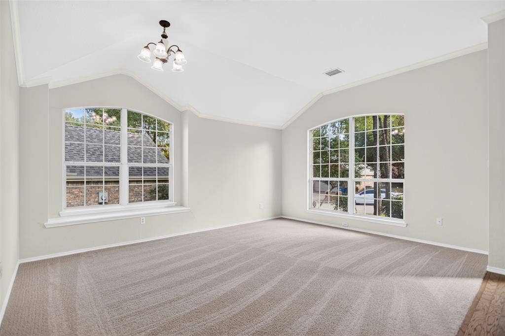 2691 Eganridge Lane, Rockwall, TX 75087 Vaulted ceilings featuring a multi-arm chandelier, large arched windows, and wall-to-wall carpeting