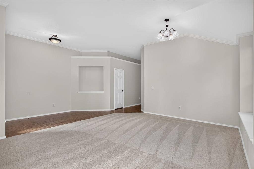 2691 Eganridge Lane, Rockwall, TX 75087 Living area featuring vaulted ceilings, recessed wall niche, neutral carpeting, wood-finish flooring, and multi-light chandelier