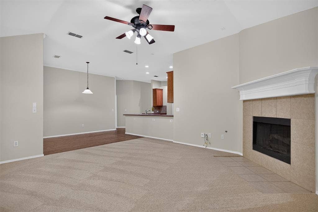 2691 Eganridge Lane, Rockwall, TX 75087 Vaulted ceilings, fireplace with a decorative mantle and tile surround, ceiling fan, and pendant lighting