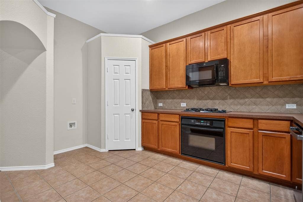 2691 Eganridge Lane, Rockwall, TX 75087 Kitchen featuring wood cabinetry, tile flooring, diagonal tile backsplash, built-in wall oven, and over-the-range microwave