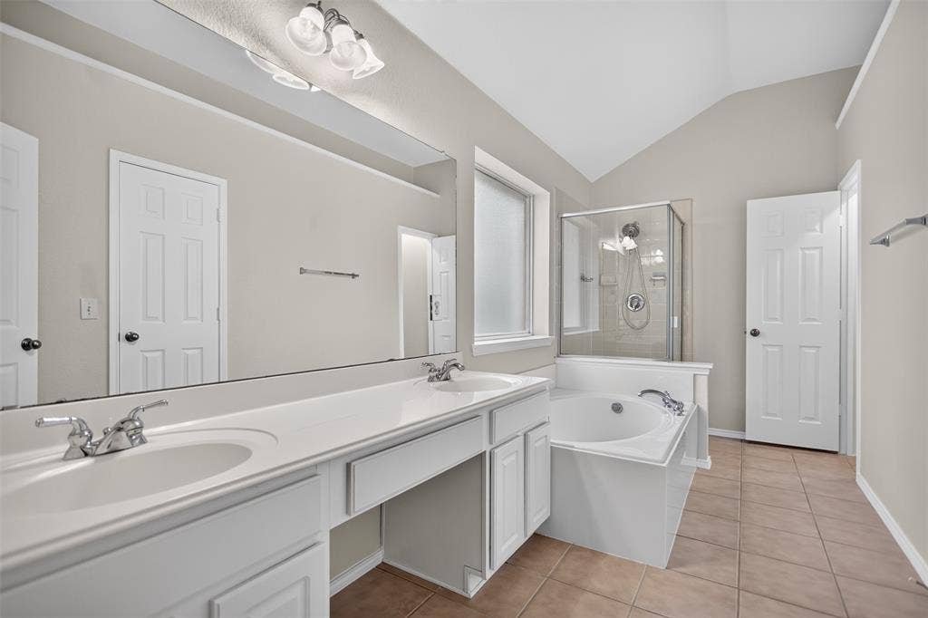 2691 Eganridge Lane, Rockwall, TX 75087 Bathroom featuring a dual-sink vanity with white cabinetry, a large wall-to-wall mirror, an integrated soaking tub, and a glass-enclosed shower