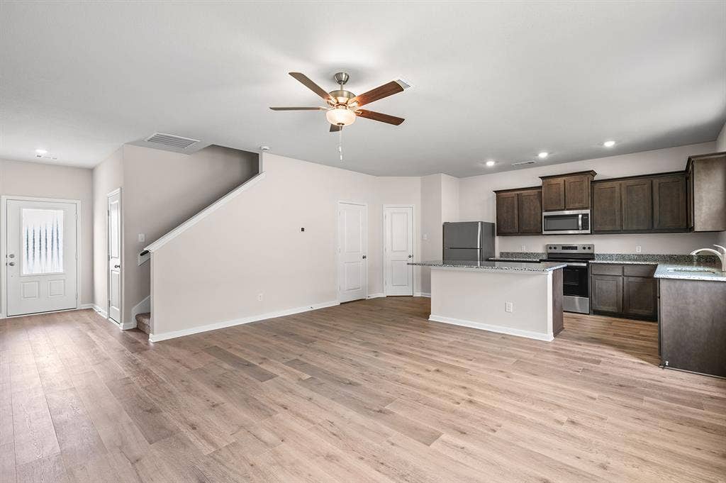6307 Crosswood Lane, Dallas, TX 75241 Kitchen featuring dark brown cabinetry, recessed lighting, a center island, appliances with stainless steel finishes, and light wood finished floors