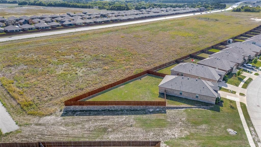 Expansive residential lot featuring an angular perimeter, private wood privacy fencing, and an elevated stone retaining wall