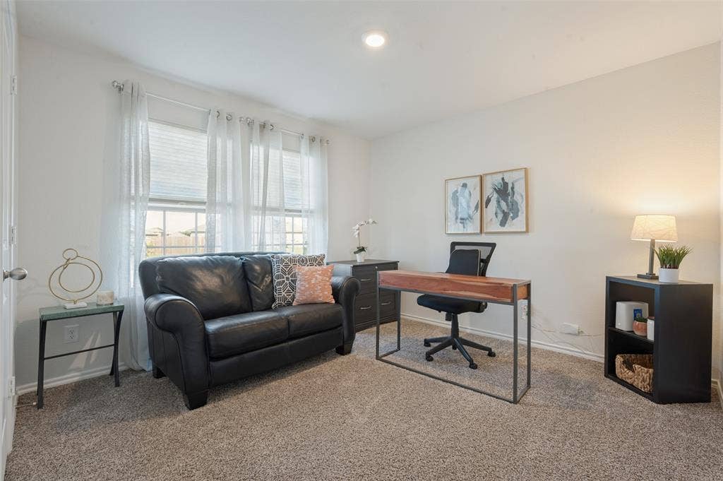 Neutral interior space featuring carpeted flooring, dual-pane windows, and a recessed ceiling light