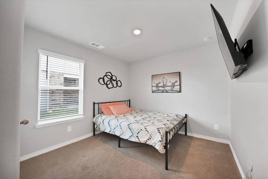 Neutral wall tones, wall-to-wall carpeting, and a single-hung window with blinds