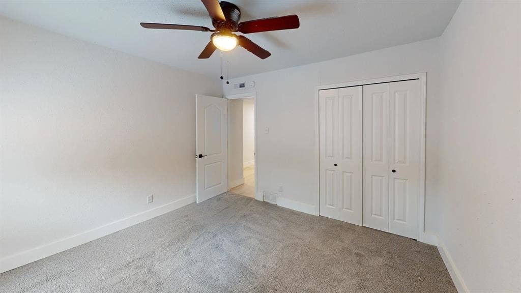 1506 W Spring Creek Parkway, Plano, TX 75023 Room featuring neutral carpeting, a ceiling-mounted light fixture with a fan, and a double-door closet