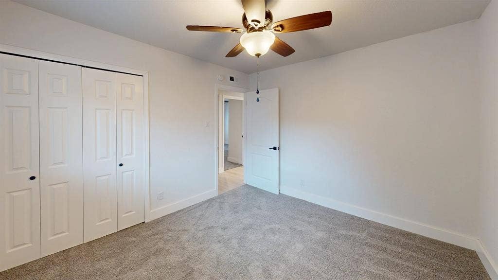 1506 W Spring Creek Parkway, Plano, TX 75023 Neutral interior room featuring neutral carpeting, a ceiling fan with integrated lighting, and white bi-fold closet doors