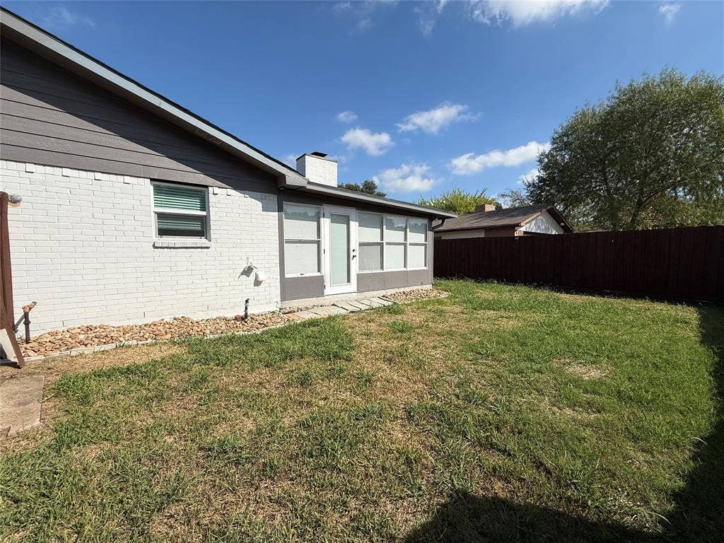 1506 W Spring Creek Parkway, Plano, TX 75023 Exterior facade featuring painted brick, horizontal siding, an integrated chimney, and a fenced backyard