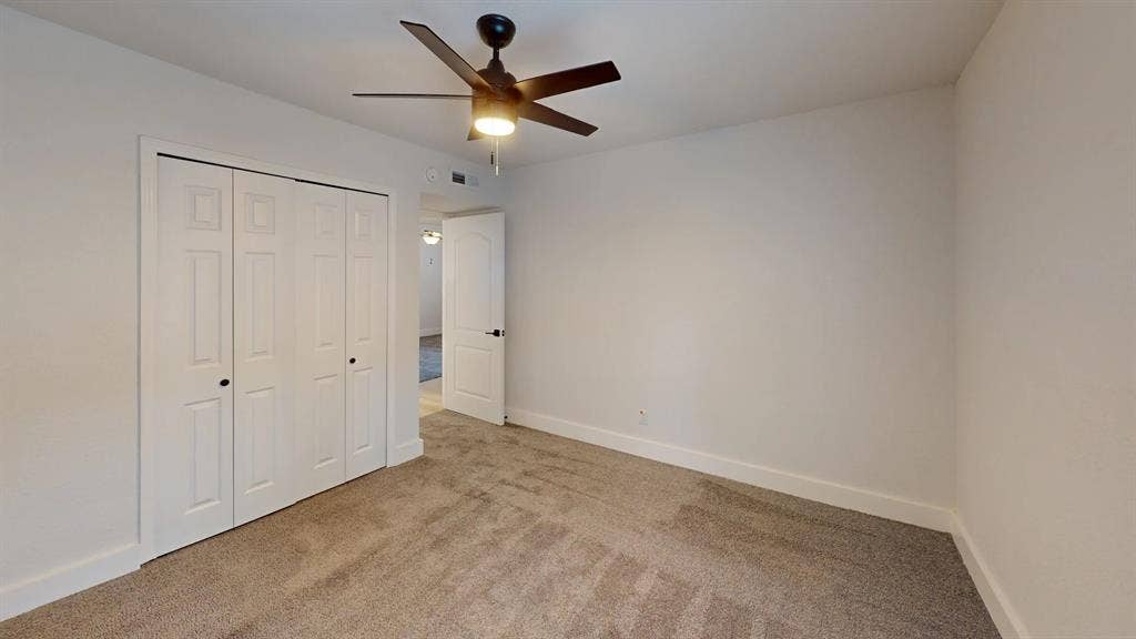 1506 W Spring Creek Parkway, Plano, TX 75023 Neutral wall finish, wall-to-wall carpeting, bi-fold closet doors, and a ceiling fan with integrated lighting