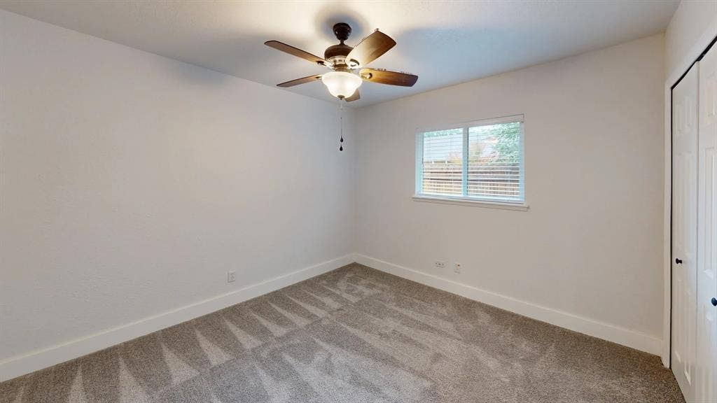 1506 W Spring Creek Parkway, Plano, TX 75023 Neutral-toned wall-to-wall carpeting, ceiling fan with integrated light fixture, dual-panel closet doors, and sliding window