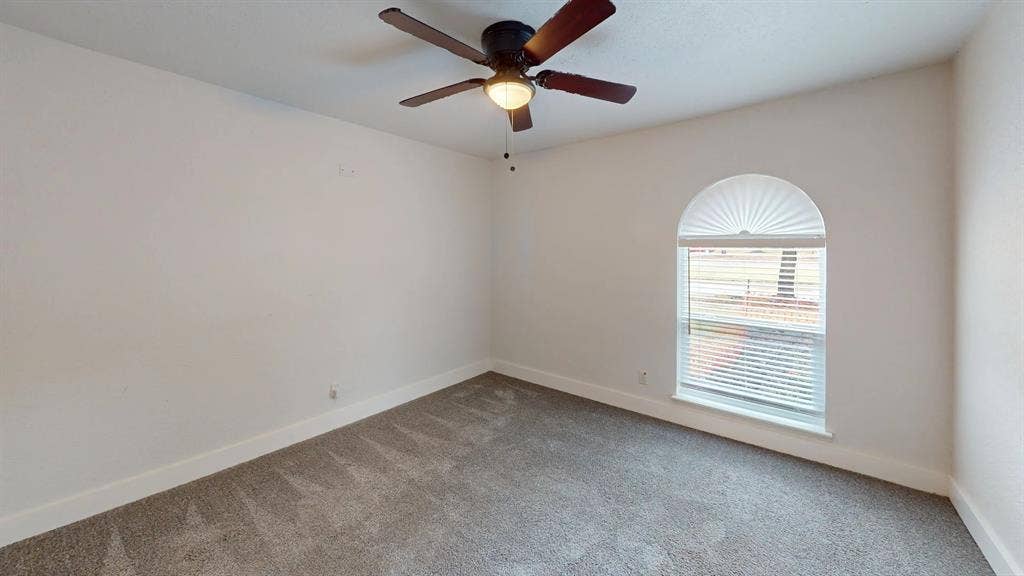 1506 W Spring Creek Parkway, Plano, TX 75023 Neutral-toned carpeted flooring, vaulted arched window, and overhead ceiling fan with light fixture