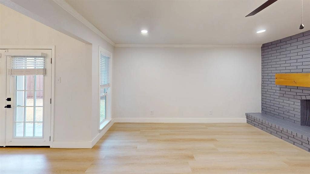 1506 W Spring Creek Parkway, Plano, TX 75023 Living area featuring wood-finish flooring, a painted brick fireplace with a wood mantel, recessed lighting, and a glass-paneled exterior door