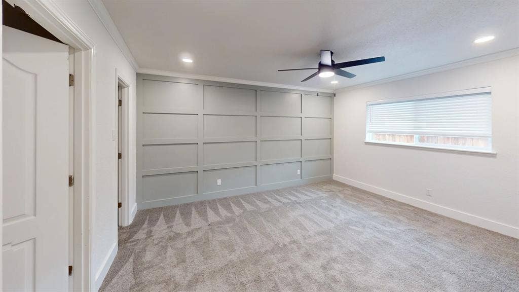 1506 W Spring Creek Parkway, Plano, TX 75023 Grey-painted wainscoting accent wall, recessed lighting, ceiling fan with integrated lighting, neutral wall-to-wall carpeting, and horizontal window blinds