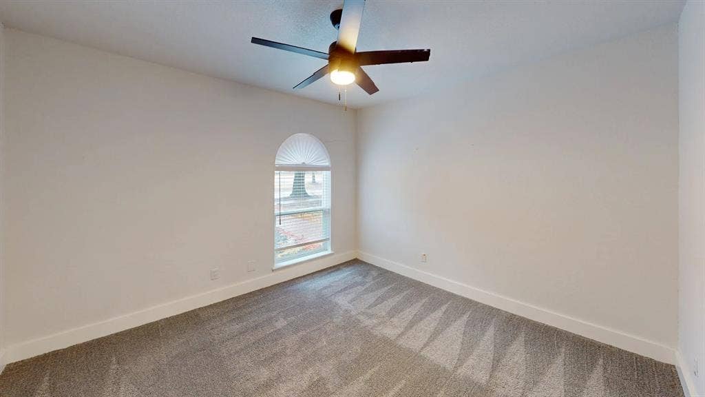 1506 W Spring Creek Parkway, Plano, TX 75023 Room featuring neutral carpeting, an arched window, and a ceiling fan with integrated lighting