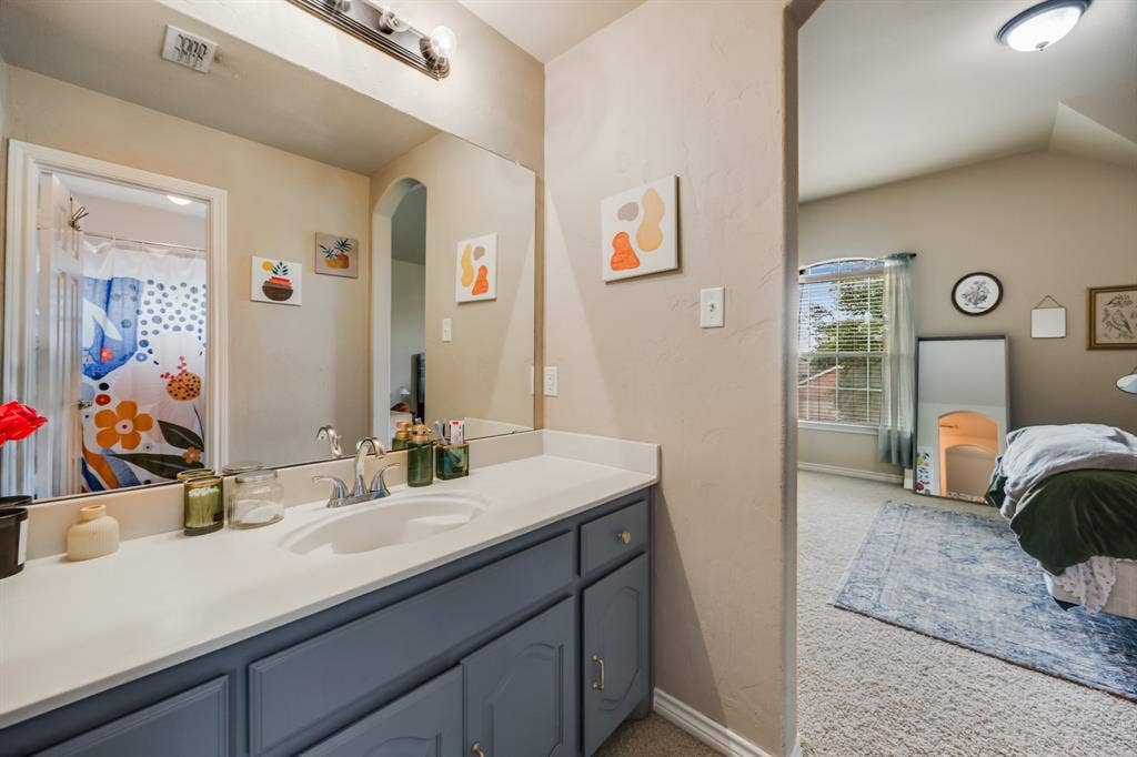 Bathroom featuring vanity and lofted ceiling
