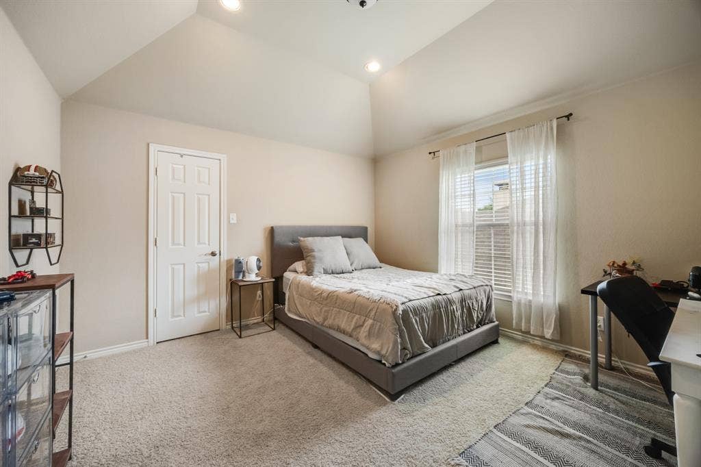 Carpeted bedroom featuring lofted ceiling, recessed lighting, and a desk