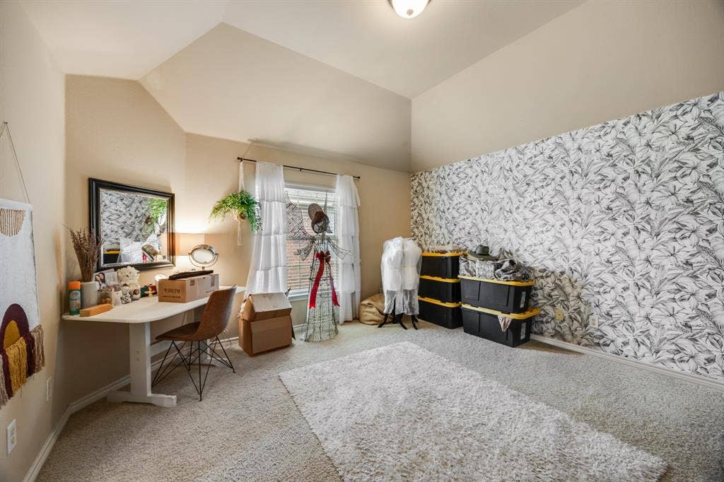 Office space with light colored carpet and vaulted ceiling