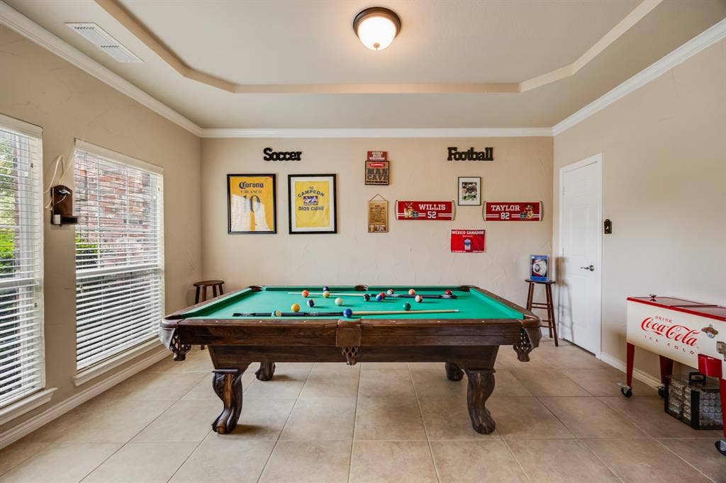 Game room featuring a raised ceiling, billiards, ornamental molding, and tile patterned flooring