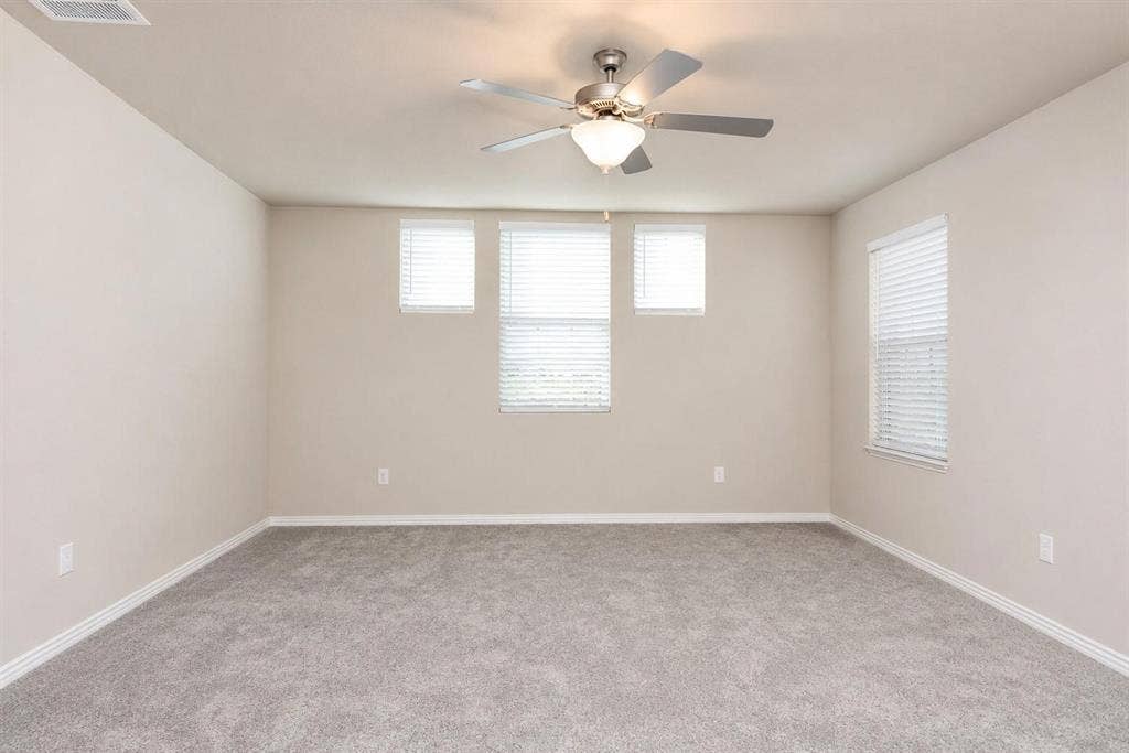 3704 Banton Street, Rowlett, TX 75089 Neutral wall tones, carpeted flooring, multi-pane window configuration, and a central ceiling fan with integrated lighting