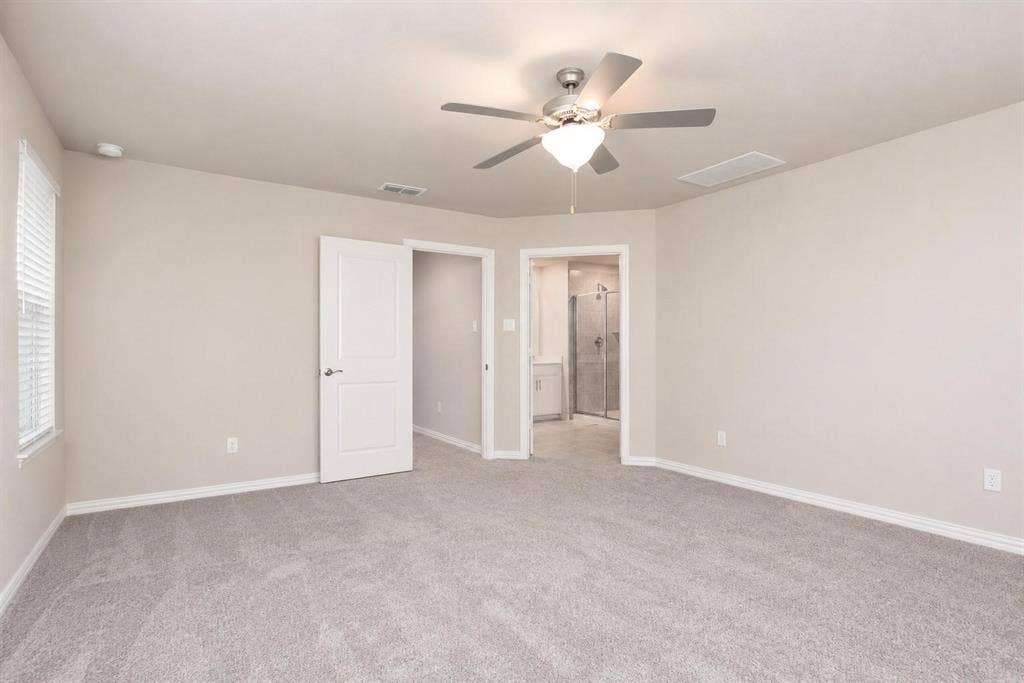 3704 Banton Street, Rowlett, TX 75089 Neutral-toned interior featuring plush carpeting, a central ceiling fan with integrated lighting, and white paneled doors