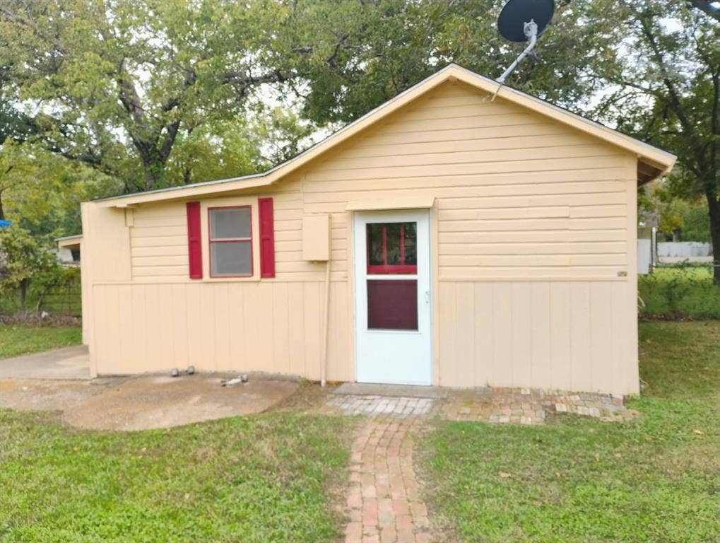 412 N Saint Augustine Drive, Dallas, TX 75217 Amazing clean and comforatble space home is with exterior featuring horizontal lap siding, red window shutters, a white storm door, and a brick walkway, ready for your hanging of your welcome-to-my home wreath.