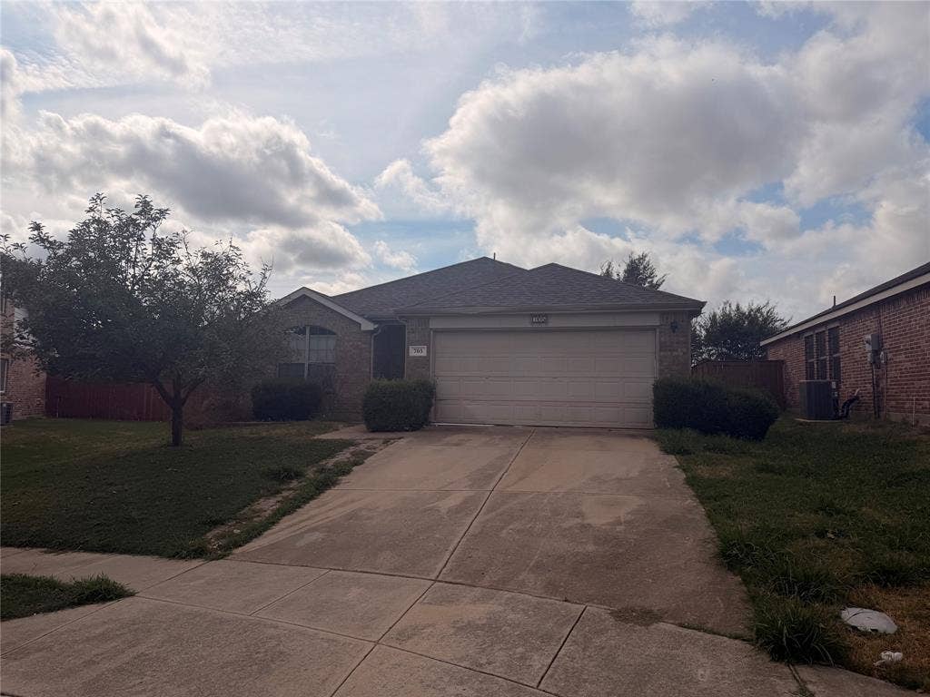 705 Bamboo Drive, Anna, TX 75409 Single-story brick exterior featuring an attached two-car garage, concrete driveway, and arched window detailing