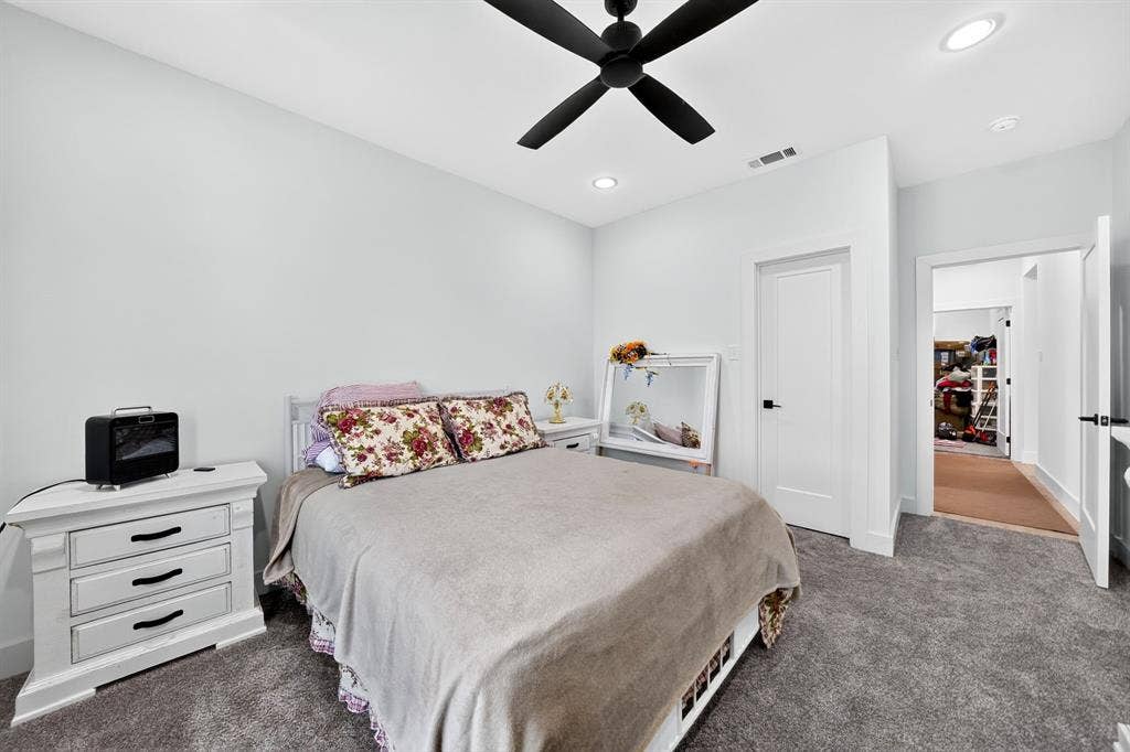 Neutral-toned room featuring plush carpeting, a black matte ceiling fan, recessed lighting, and solid-core doors with black hardware